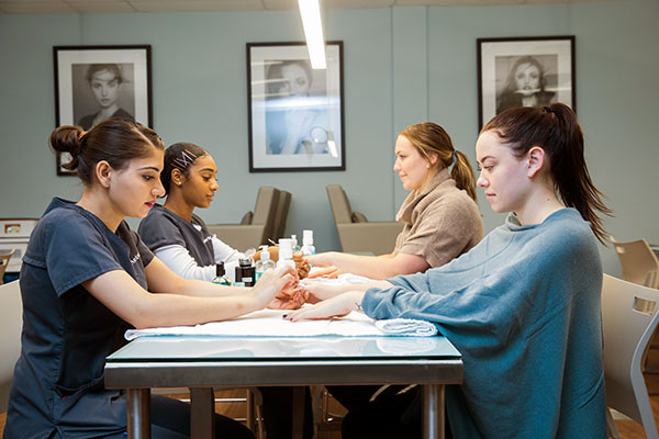 two students giving two clients manicures