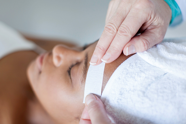 woman getting eyebrow waxed